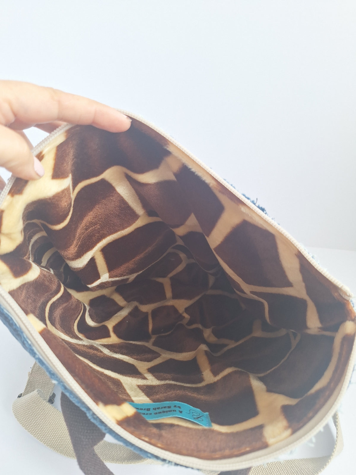 The Backpack: blue denim with giraffe print lining